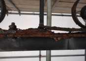 Rust jacking and decay where the original overthrow is fixed to the modern support beam.