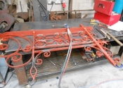 The brackets laid out on the workshop bench. Red oxide paint has been used 